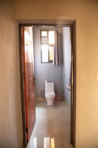 a bathroom with a toilet and a window at Ruhuka House in Bujumbura