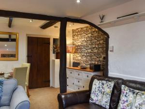 a living room with a couch and a stone wall at Byways in Cartmel
