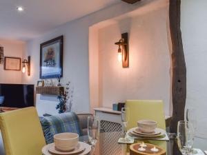 a dining room with a table and yellow chairs at Byways in Cartmel