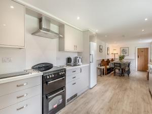 a kitchen with white appliances and a living room at Peaceful Farmhouse - Uk44787 in Grainthorpe