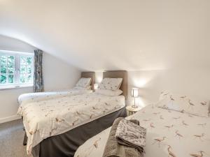 Peaceful Farmhouse - Uk44787 في Grainthorpe: سريرين في غرفة بجدران بيضاء