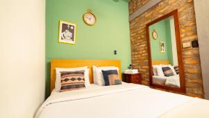a bedroom with a bed and a clock on the wall at Socialtel Candelaria Bogotá in Bogotá