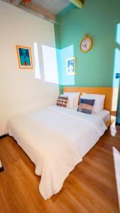 a large white bed in a room with a clock on the wall at Socialtel Candelaria Bogotá in Bogotá