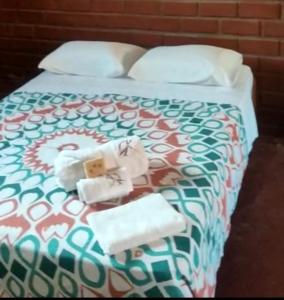1 dormitorio con 1 cama con toallas en ALMÁZYGO Bed & Breakfast, en Tarapoto