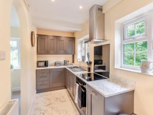 a kitchen with gray cabinets and marble counter tops at Strawberry Field - Uk45169 in Southwell