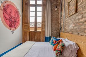 a bedroom with a bed and a brick wall at Socialtel Candelaria Bogotá in Bogotá