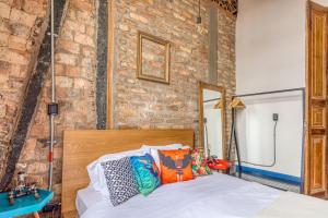 a bedroom with a bed and a brick wall at Socialtel Candelaria Bogotá in Bogotá