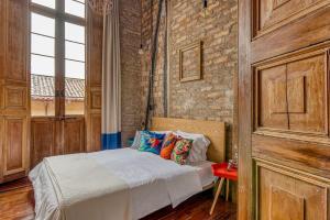 a bedroom with a bed and a brick wall at Socialtel Candelaria Bogotá in Bogotá