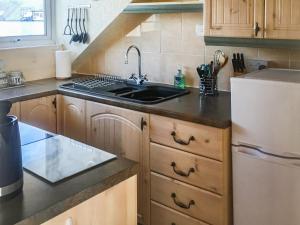 a kitchen with a sink and a white refrigerator at Harbour Cottage in Millom