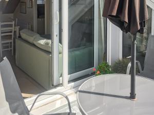 a glass table and a chair in front of a window at Harbour Cottage in Millom