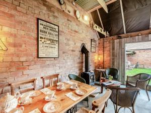 a dining room with a table and chairs and a brick wall at Peaceful Travelers Rest - Uk44790 in Grainthorpe