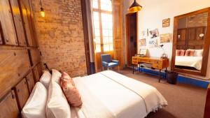 a bedroom with a bed and a desk with a mirror at Socialtel Candelaria Bogotá in Bogotá
