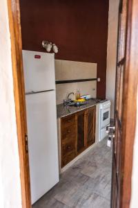 a kitchen with a white refrigerator and a sink at El Campo in Sierra de la Ventana