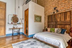 a bedroom with a bed and a brick wall at Socialtel Candelaria Bogotá in Bogotá