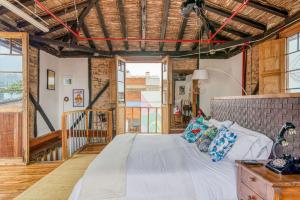 a bedroom with a large bed in a room with windows at Socialtel Candelaria Bogotá in Bogotá