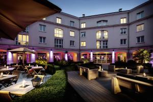 un hôtel avec des tables et des chaises devant un bâtiment dans l'établissement pentahotel Paris Charles de Gaulle, à Roissy-en-France