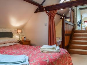 a bedroom with a bed with a red blanket at The Barn in Ramsden