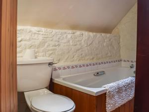 a bathroom with a toilet and a bath tub at The Barn in Ramsden