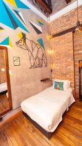 a bed in a room with a mural on the wall at Socialtel Candelaria Bogotá in Bogotá