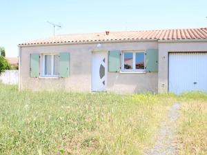 una pequeña casa con puertas verdes y un campo de césped en Maison Aytré, 3 pièces, 6 personnes - FR-1-246-561, en Aytré
