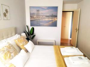 um quarto com uma cama branca e uma fotografia na parede em Lisbon Relax Pool Apartment - Free Parking Garage em Lisboa