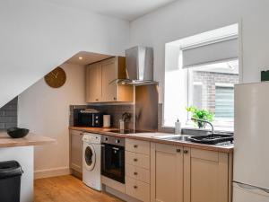 a kitchen with a sink and a washer and dryer at The Hamilton Collection - Waterloo Place in Spittal