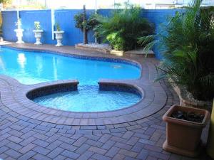 mały basen na ceglanym patio w obiekcie Centrepoint Motor Inn w mieście Rockhampton