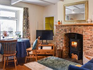 a living room with a table and a fireplace at Wellgate in Middlesmoor