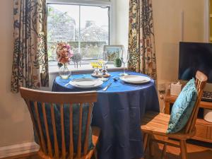 Wellgate في Middlesmoor: طاولة طعام مع قماش الطاولة الزرقاء وكرسيين