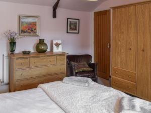 Wellgate في Middlesmoor: غرفة نوم بسرير وخزانة وكرسي
