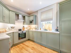 a kitchen with white cabinets and a wooden floor at The Chambers in Richmond