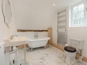 a bathroom with a tub and a toilet and a sink at The Farmhouse - Uk45171 in Southwell