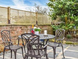 uma mesa com quatro cadeiras e uma mesa com em Ugly Duckling Cottage em Broughton in Furness