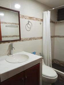 a bathroom with a sink and a toilet and a mirror at Raymi Inn MachuPicchu in Machu Picchu