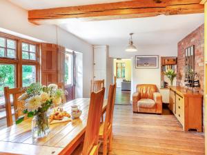 een keuken en eetkamer met een houten tafel bij Fern Bank Cottage in Parkend