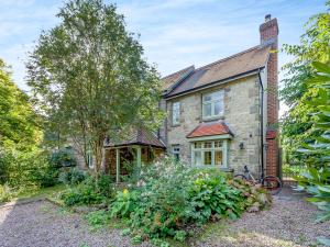 an old stone house with a garden in front of it at Fern Bank Cottage in Parkend