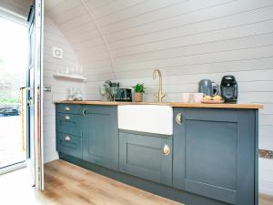 a kitchen with blue cabinets and a sink at Rackenford- Uk40033 in East Anstey