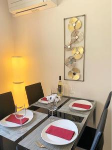 uma mesa de jantar com pratos vermelhos e brancos e copos de vinho em Lisbon Relax Pool Apartment - Free Parking Garage em Lisboa
