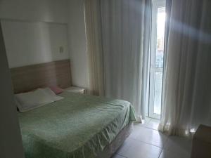 a bedroom with a bed and a large window at 1/4 na praia de Armação in Salvador +33 photos