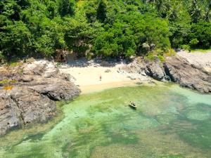 an aerial view of a beach with a boat in the water at L'Astrolabe - Ocean View Tiny House in Baras +19 photos