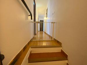 un corridoio con una scala con pavimenti in legno e pareti bianche di Villa la Commanderie a Pontevès