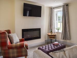 a living room with a couch and a fireplace at Swiss Cottage in Scotforth