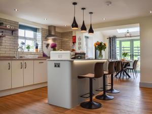 a kitchen with white cabinets and a table with chairs at Swiss Cottage in Scotforth