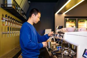 Um homem está a trabalhar num café. em Dayin East Nanjing Road & The Bund em Xangai