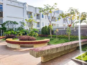 due panche in un parco di fronte a un edificio di Parahyangan Residences by AYA Stays a Bandung