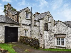 una antigua casa de piedra con un gran garaje en Needle House en Ravenstonedale