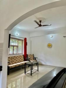 a living room with a couch and a window at Sober 2bhk Pet Friendly Apartment with pool view in Marmagao