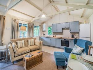 a living room with a couch and a kitchen at Peaceful Woodland Lodge in Cornisholme