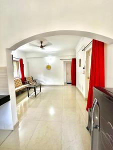 a large living room with red curtains and a couch at Sober 2bhk Pet Friendly Apartment with pool view in Marmagao