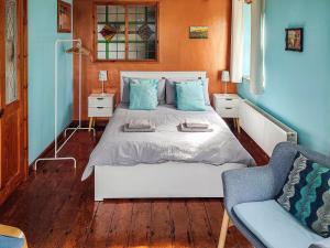 - une chambre avec un lit aux murs bleus et un canapé dans l'établissement Ceiliog Bach, à Llangennith